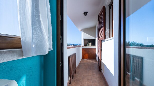A narrow balcony with a view of the sky and a distant landscape.