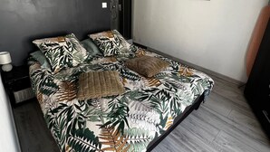 Un dormitorio moderno con una cama, ducha y un cuadro en la pared.