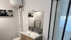 Un baño moderno con inodoro, lavamanos y ducha.