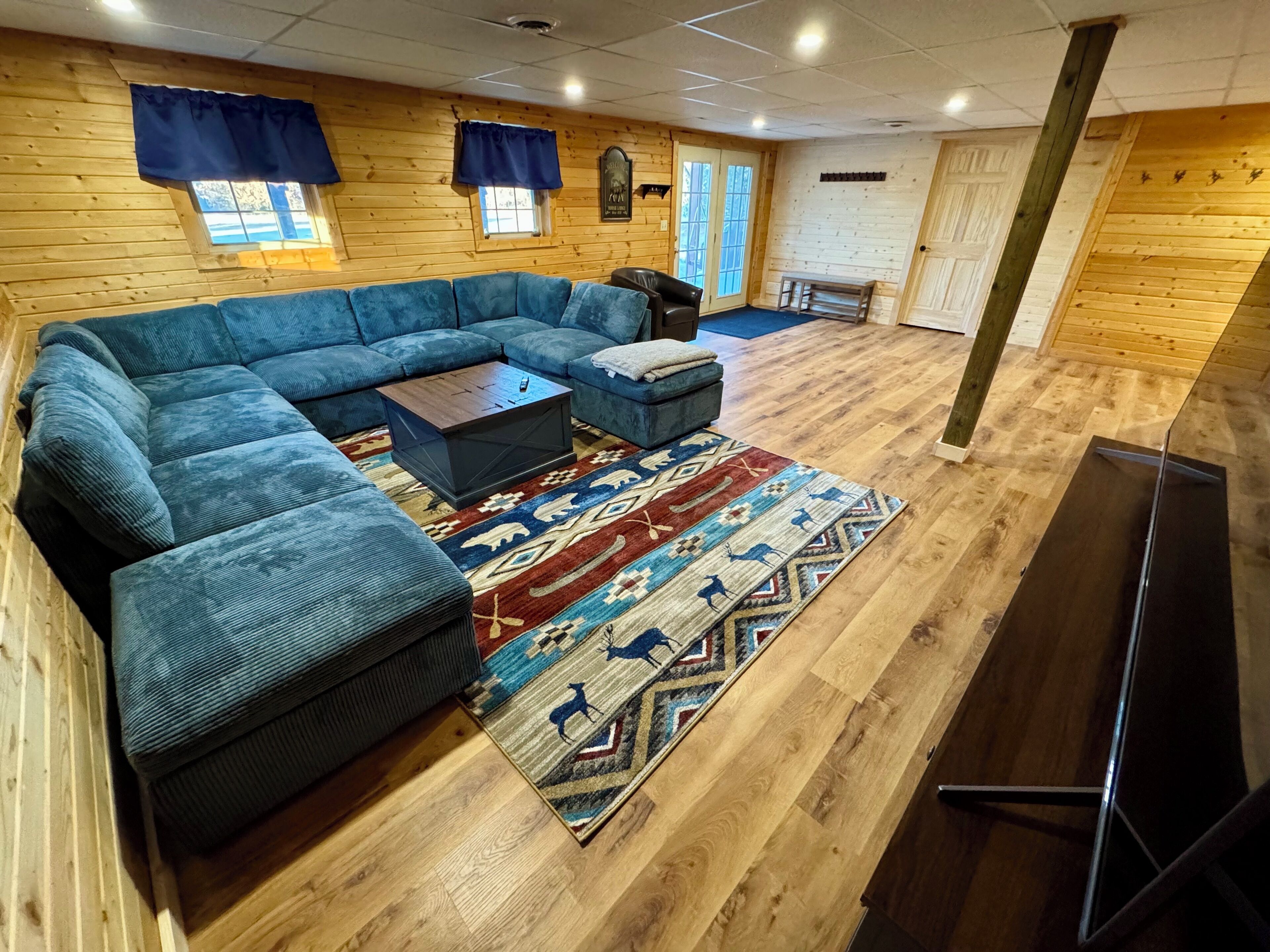 A living room with a sectional sofa, a coffee table, and a patterned rug.