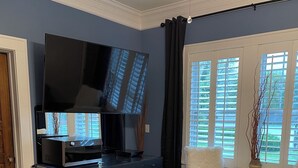A bedroom with a bed, a desk, a chair, a television, and a window with blinds. - Beautiful,comfortable, safe suite with private entrance. (Dallas)
