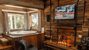 A modern interior with a fireplace, a TV mounted on the wall, and a seating area with a rug. - Roteiros Adorai (Piedade)