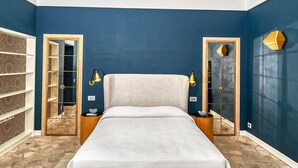 Une chambre avec un grand lit, un ventilateur de plafond et un sol imitant la pierre.