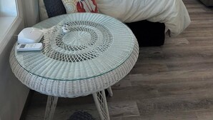 A bedroom with a bed, a round table with a scale, and a chair.