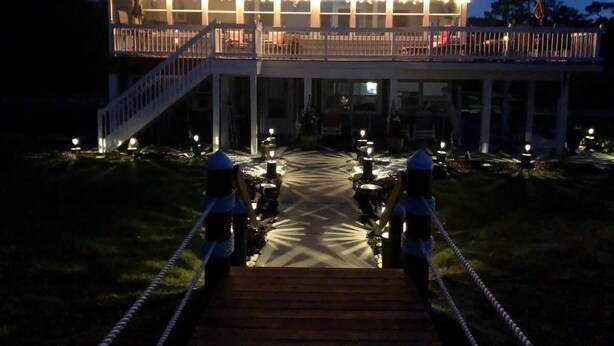 A building with a balcony and a pathway leading to it.