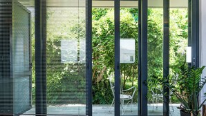Un intérieur moderne avec une porte-fenêtre coulissante donnant sur un jardin.