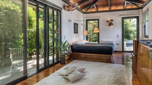 Une chambre à coucher moderne avec un grand lit, un plafond en bois et une vue sur l’extérieur.