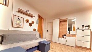 A modern living room with a sofa, a coffee table, a wardrobe, and a mirror. - House Bernstein, Apartman 3 (Haus im Ennstal)