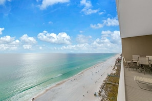 Ein Balkon mit Blick auf Strand und Meer.