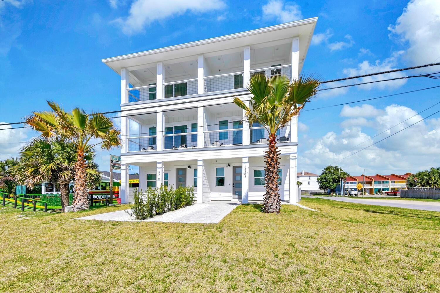 A two-story building with a flat roof, large windows, and a balcony on the upper floor.