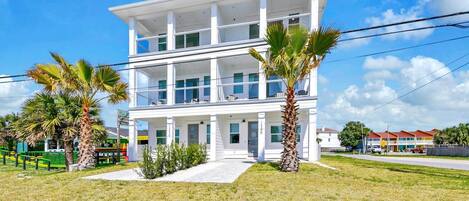 A two-story building with a flat roof, large windows, and a balcony on the upper floor.