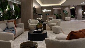 A modern hotel lobby with sofas, a coffee table, and a reception desk. - La Résidence Panamá (Panama City)