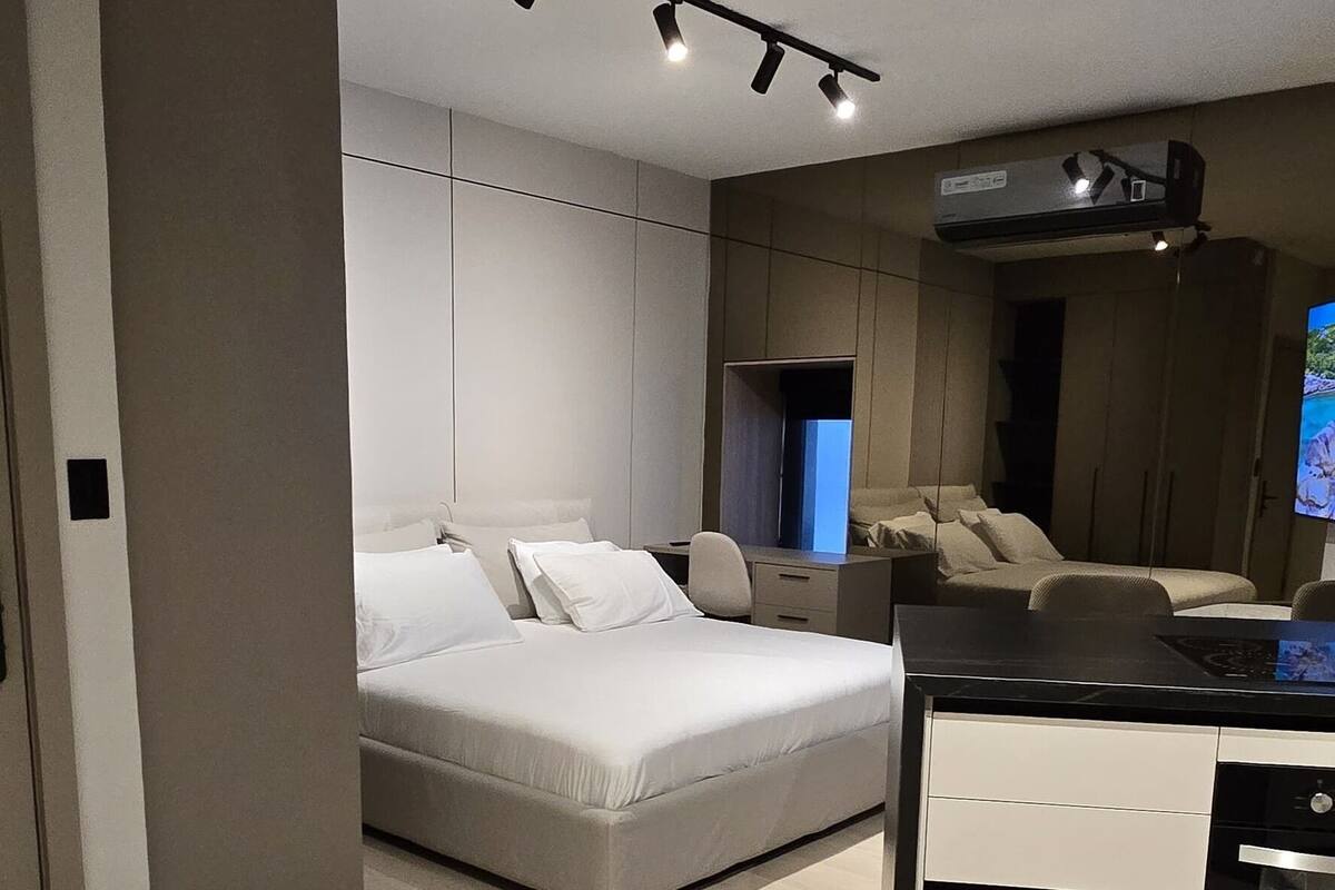 A modern bedroom with a large bed, bedside tables, and a built-in wardrobe.