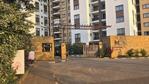 A gated entrance to a residential building with multiple balconies and a sign reading "MI VIDA Garden City". - A vibrant and connected hub blending urban living, green spaces, and convenience (Nairobi)