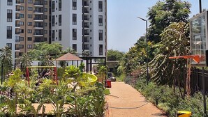 A residential area with multi-story buildings, a paved pathway, and greenery. - A vibrant and connected hub blending urban living, green spaces, and convenience (Nairobi)