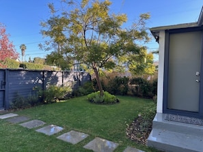 Enjoy a serene outdoor space with a beautifully manicured lawn and lush greenery.