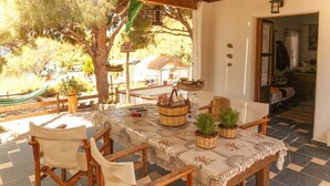 An outdoor dining area with a table set for four, surrounded by wooden chairs. There are wicker baskets and a potted plant on the table. - Entire Villa in Kalymnos, Greece
5 guests1 bedroom3 beds1.5 bathrooms (Kalymnos)