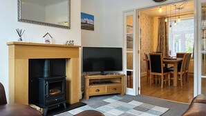 Una sala de estar con chimenea, televisor y comedor.