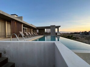 A rooftop pool with a clear view of the city skyline, modern architecture, and a calm water surface.
