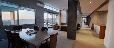Un interior moderno con comedor, ventanas amplias y vistas a la ciudad.