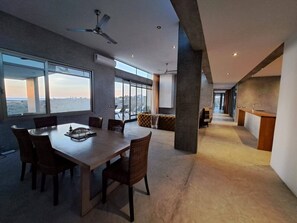 A modern interior with a dining area, large windows, and a view of the city. - Arroyo Escondido -Luxe Oceanview Contemporary Home (Todos Santos)