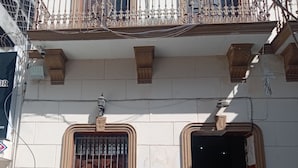 A building facade with two arched windows, a balcony with ornate metal railings, and a number '45' on the wall. - OYO Hotel El Conquistador (Veracruz)