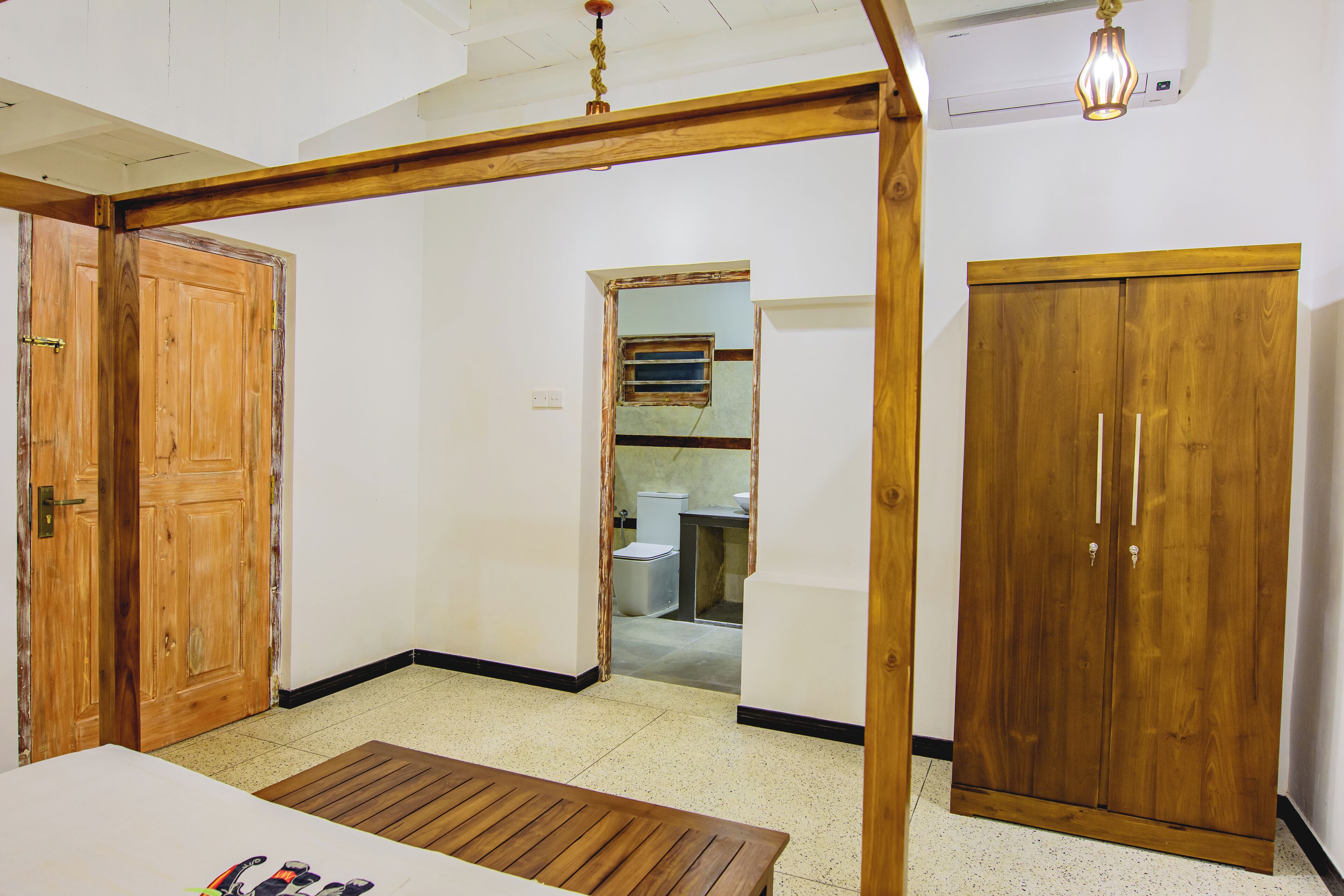 A room with a wooden door, a wardrobe, and a bench.