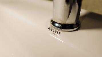 A close-up of a sink faucet with the brand name "Verona" visible.