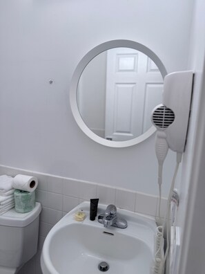 Een haardroger, handdoeken, zeep, toiletpapier