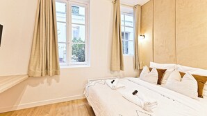 Ein Hotelzimmer mit Bett, Vorhängen, einem Fenster und Blick nach draußen.