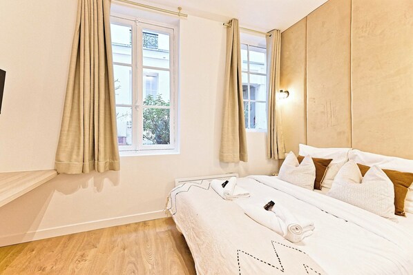 A hotel room with a bed, curtains, a window, and a view of the outside. - Superb Air-conditioned Flat Galeries Lafayette (Paris)