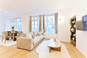 A modern living room with a sofa, coffee table, and dining area. - Superb Air-conditioned Flat Galeries Lafayette (Paris)