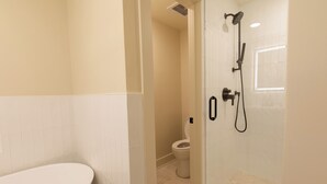 Ein Badezimmer mit Dusche, Toilette und Badewanne.