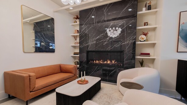Ein modernes Wohnzimmer mit Kamin, Sofa, Couchtisch und Bücherregal.