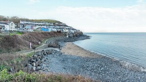 A coastal town with a rocky beach, a promenade, and colorful houses. - 3 bedroom accommodation in New Quay (New Quay)