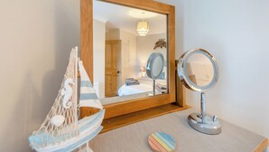 A wooden-framed mirror with a round base, a small round mirror, and a decorative hanging chair with a striped cushion. - 3 bedroom accommodation in New Quay (New Quay)