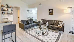 A modern living room with a sofa set, a coffee table, and a decorative rug. - 2 Mi to Golfing: Chic & Cozy Retreat in Lakeland! (Lakeland)