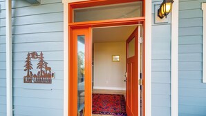 A wooden door with a red frame and glass panels, leading to a room with a patterned rug and a small rug at the entrance. - 1/2 Mi to Beach: Home w/ Patio in Ocean Shores (Ocean Shores)