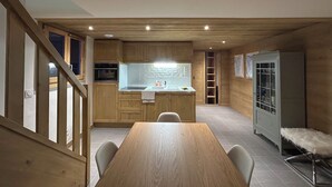 A modern kitchen with wooden cabinets, a built-in oven, and a central island with a sink.