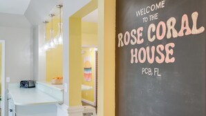 Een keuken met een schoolbord waarop staat: “Welkom bij Rose Coral House PCB, FL”.