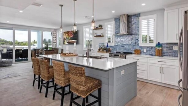 A modern kitchen with a large island, bar stools, pendant lighting, and a view to the outside. - Large Waterfront Escape, Canal Views (Tavernier)