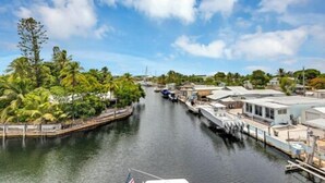 A canal with boats, surrounded by greenery and buildings. - Large Waterfront Escape, Canal Views (Tavernier)