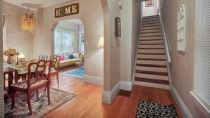 A home interior with a dining area, a staircase, and a living room.