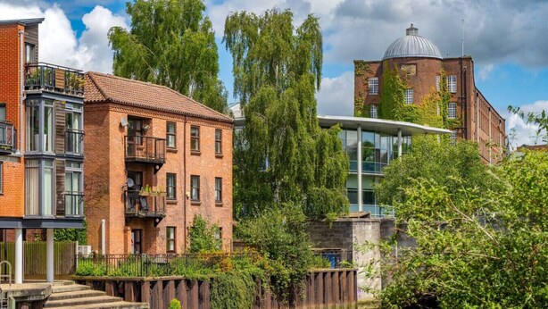 A riverside building with brick facades, a glass structure, and a dome. - Swift Host | Fishergate 2 bed | River View (Norwich)
