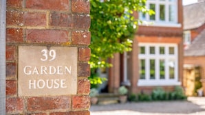 A brick wall with a sign reading "39 GARDEN HOUSE".