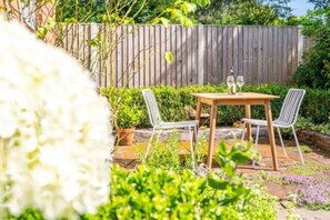 Relax in a serene outdoor space surrounded by lush greenery and a natural fence.