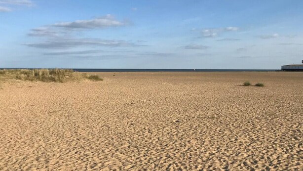 A wide sandy beach with a clear sky and a distant structure. - Swift Host: 2 bed 2 baths | On-street Free parking (Norfolk East Coast)