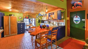 A kitchen with wooden cabinets, a dining table, and chairs. - Raven's Grotto (Flagstaff)