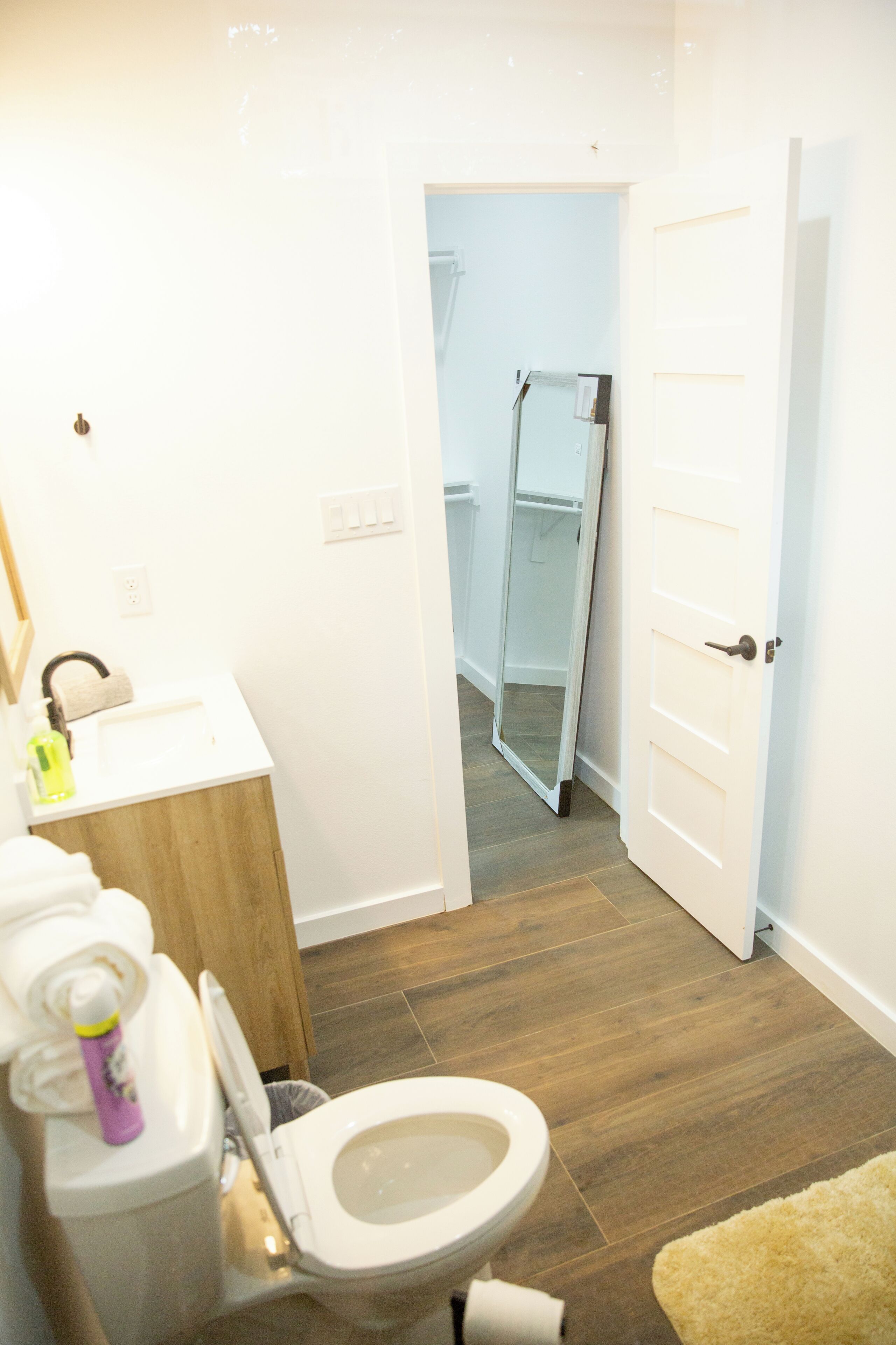 A bathroom with a toilet, sink, and a towel rack.