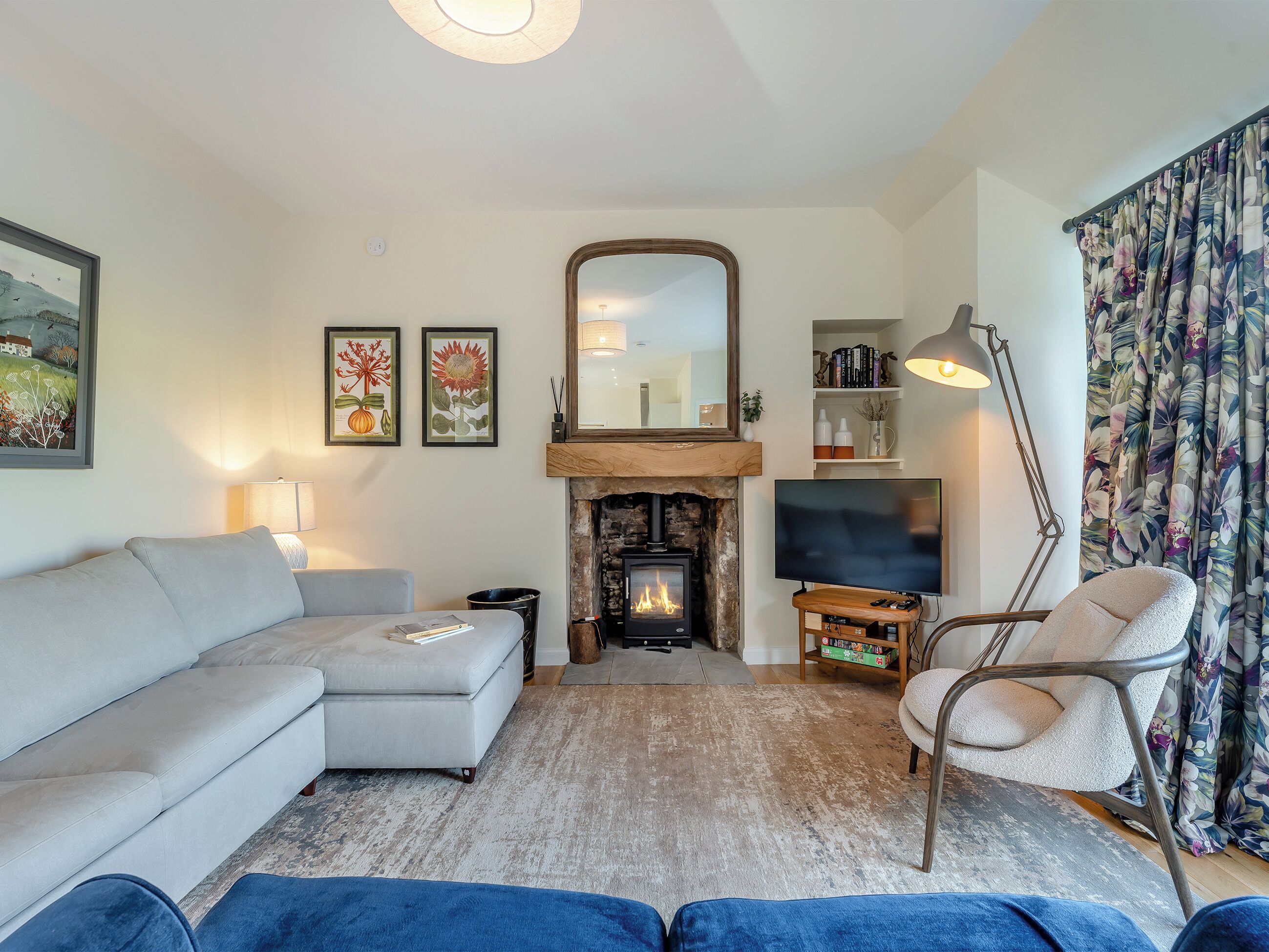 A living room with a sofa, a TV, a fireplace, and a chair.